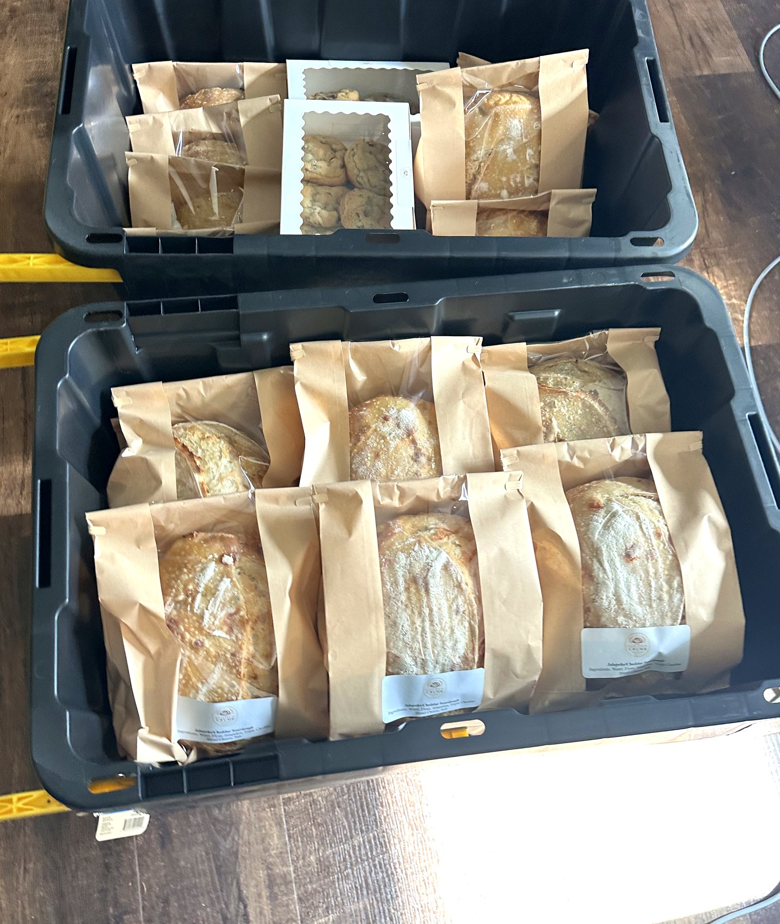 Bins of fresh sourdough loaves and cookie boxes ready for the event